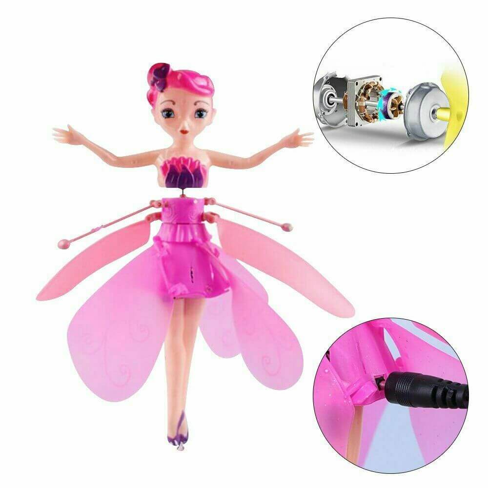 Vrolijk meisje speelt met roze zwevende feeënpop, sensorbestuurd vliegend speelgoed voor binnen.