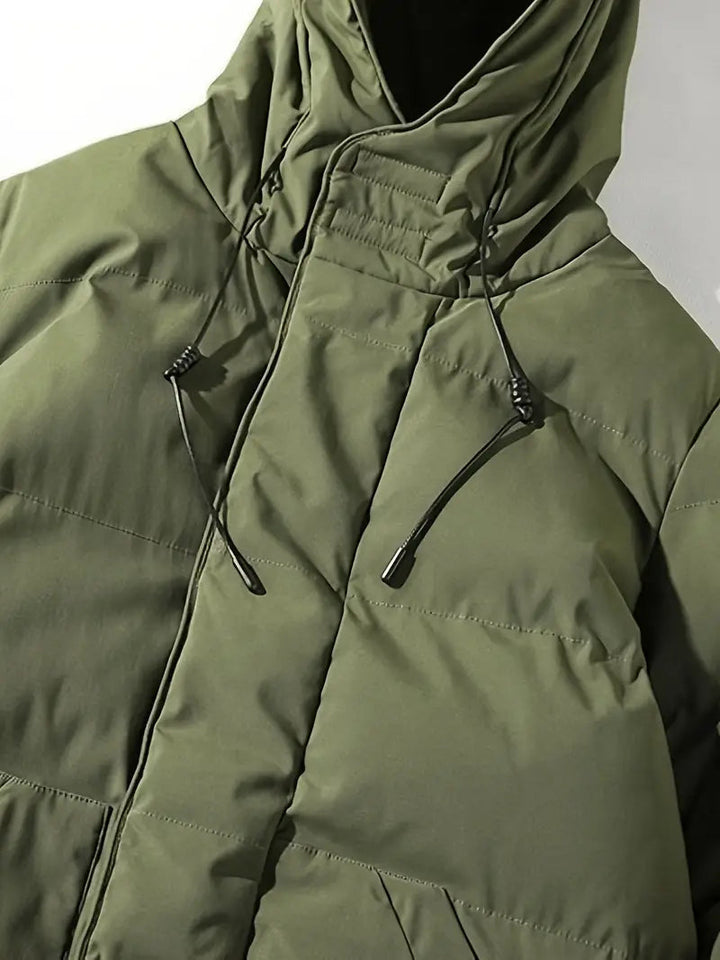 Heren winterjas: lange zwarte pufferjas met capuchon, ideaal voor een stijlvolle en warme winterlook.