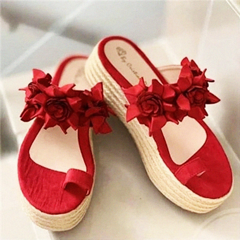 Detailopname van het bloemenaccent op deze elegante zwarte dames sandalen, symbool van zomerse mode.