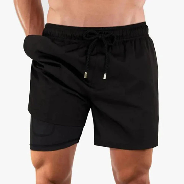 Man draagt comfortabele, sneldrogende heren zwembroek op een zonnig strand.