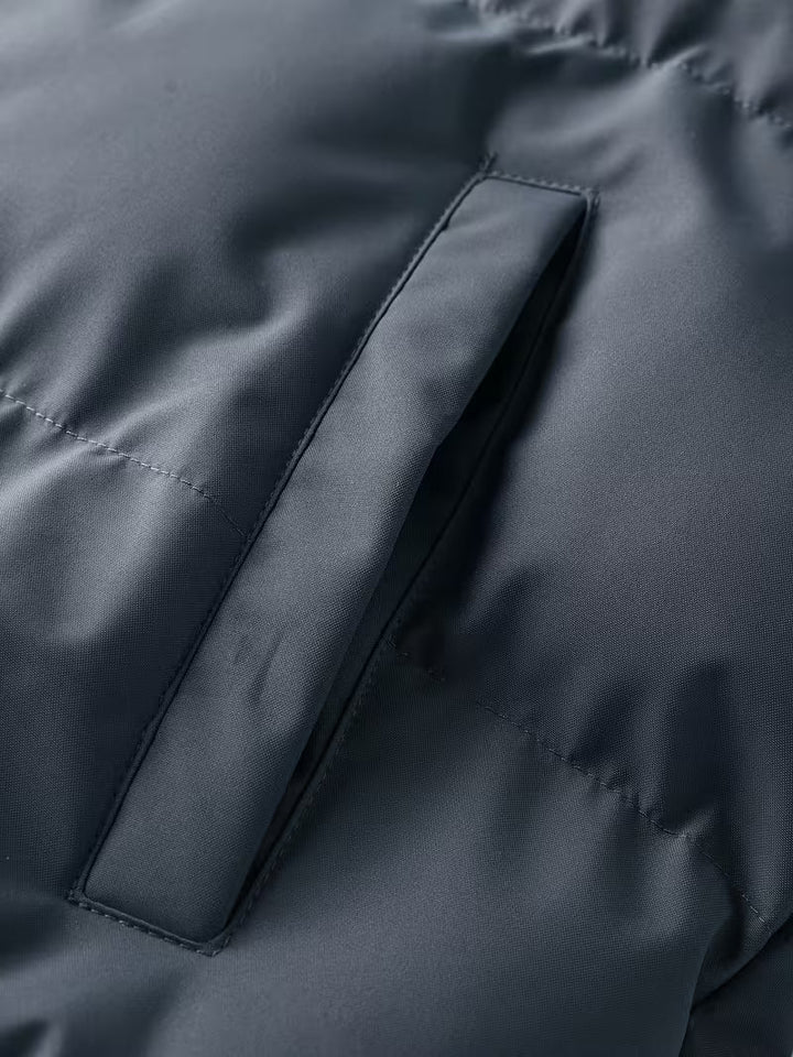 Close-up van de zachte fleece voering in de grijze gewatteerde heren winterjas met capuchon.