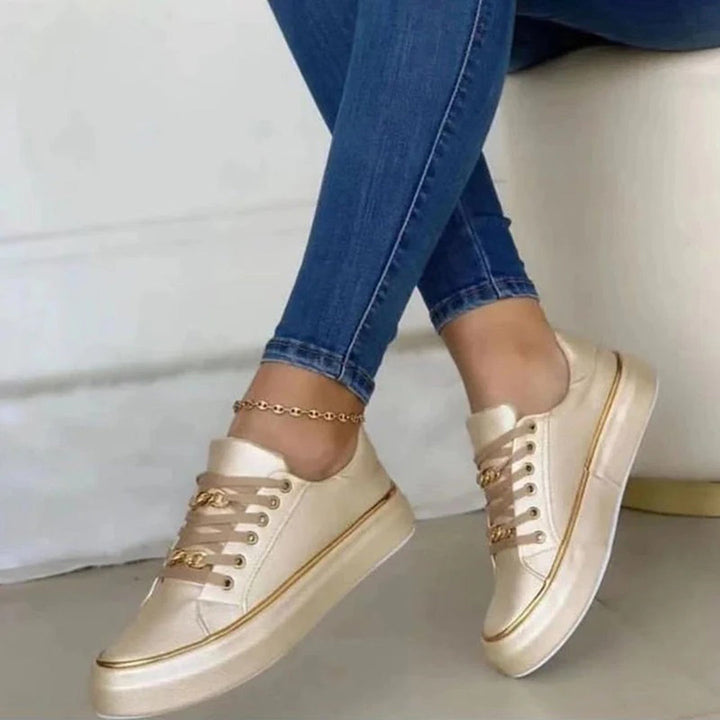 Elegante zwart-witte damessneakers met gouden details, ideaal voor een comfortabele en modieuze uitstraling.