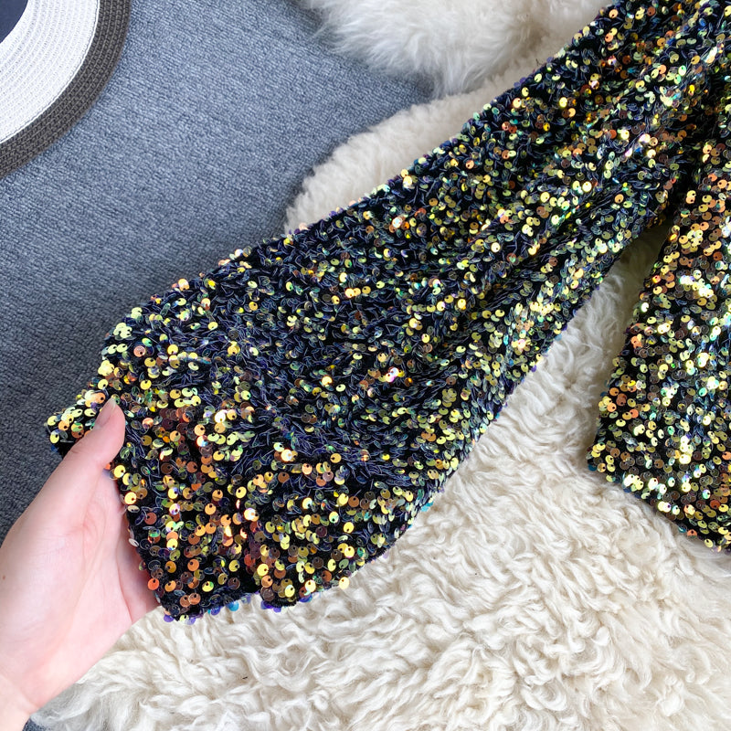 Close-up van de textuur: sprankelende pailletten op de dames one-shoulder glitter top.
