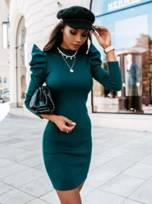 Een model draagt een stijlvolle gebreide damesjurk met pofmouwen; comfortabele elegante kleding.