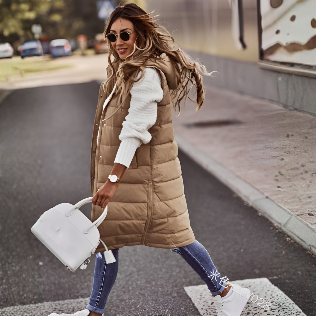 Lange dames bodywarmer met capuchon, stijlvol en comfortabel gewatteerd vest voor casual dameskleding.