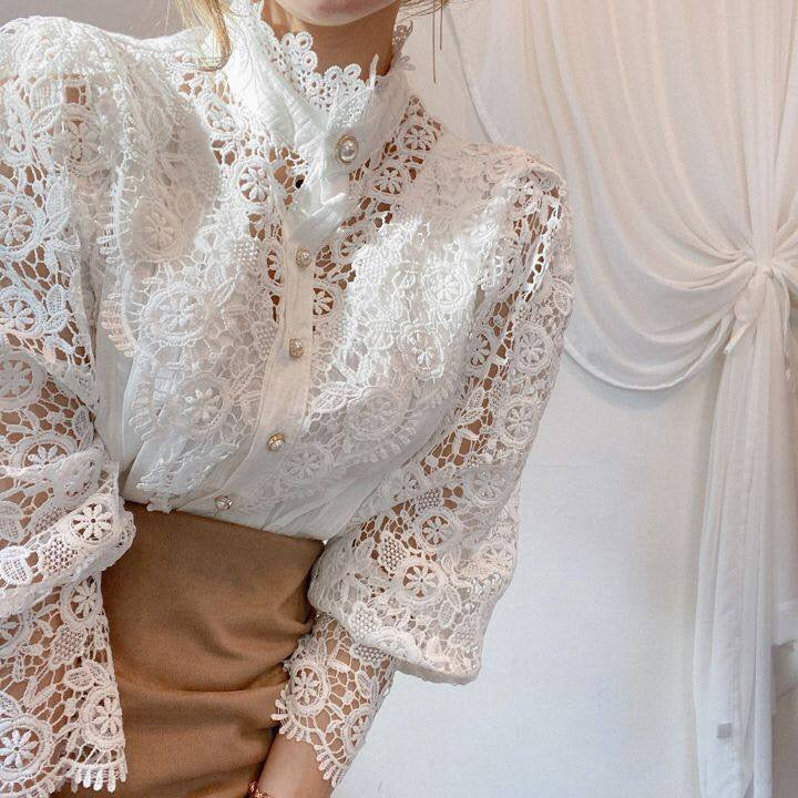 Zachte stof van de elegante damesblouse met pofmouwen en kanten details, comfortabel en modieus.