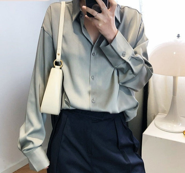 Stijlvolle damesblouse met glanzende stof en V-hals; combineerbaar voor elke modetrend.