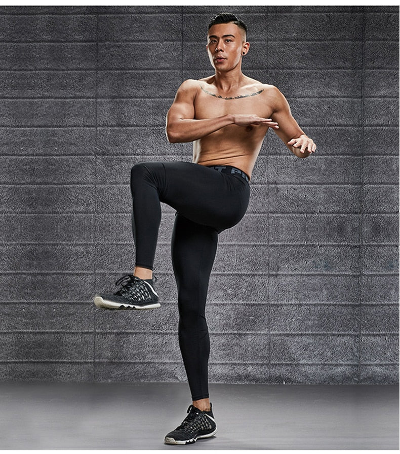 Model draagt een zwarte heren sportlegging, geschikt voor fitness en krachttraining.