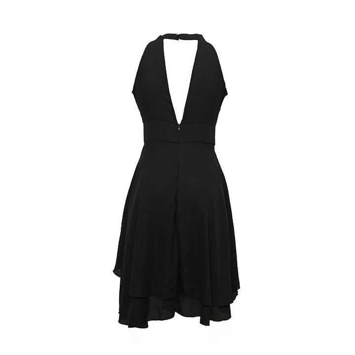 Vrouw draagt een elegante zomerse halterjurk van chiffon in een park, perfect voor een buitenfeest. Mouwloos midi model.