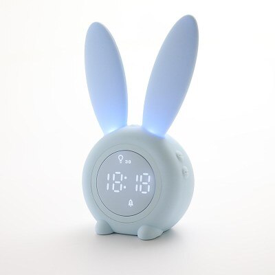 Schattige bunny kinderwekker met slaaptrainer en nachtlampje op een nachtkastje in een kinderkamer.