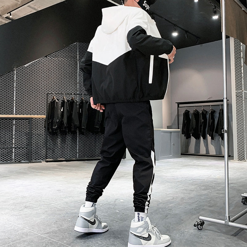 Man draagt stretch heren joggingpak Jody, een stijlvol en comfortabel tweedelig sportkleding outfit.