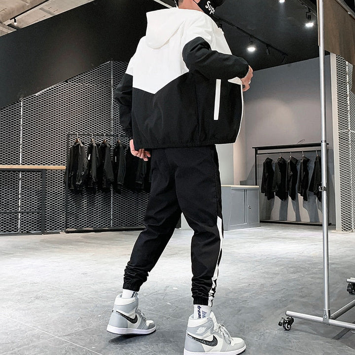 Man draagt stretch heren joggingpak Jody, een stijlvol en comfortabel tweedelig sportkleding outfit.