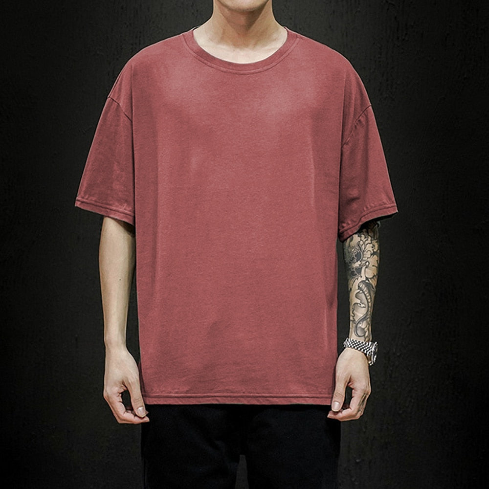 Man draagt stijlvol heren oversized T-shirt, relaxed fit, combineerbaar met jeans of shorts. Moderne zomer top.