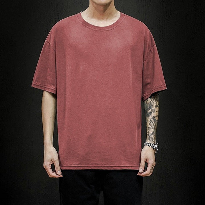 Man draagt stijlvol heren oversized T-shirt, relaxed fit, combineerbaar met jeans of shorts. Moderne zomer top.