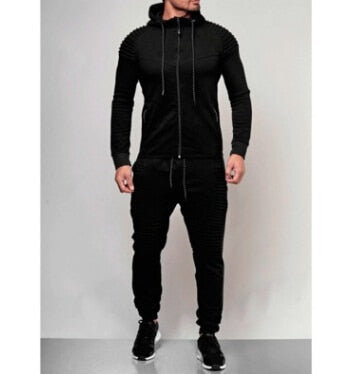 Man draagt stijlvol heren trainingspak met hoodie & joggingbroek, perfect voor casual look of sport.