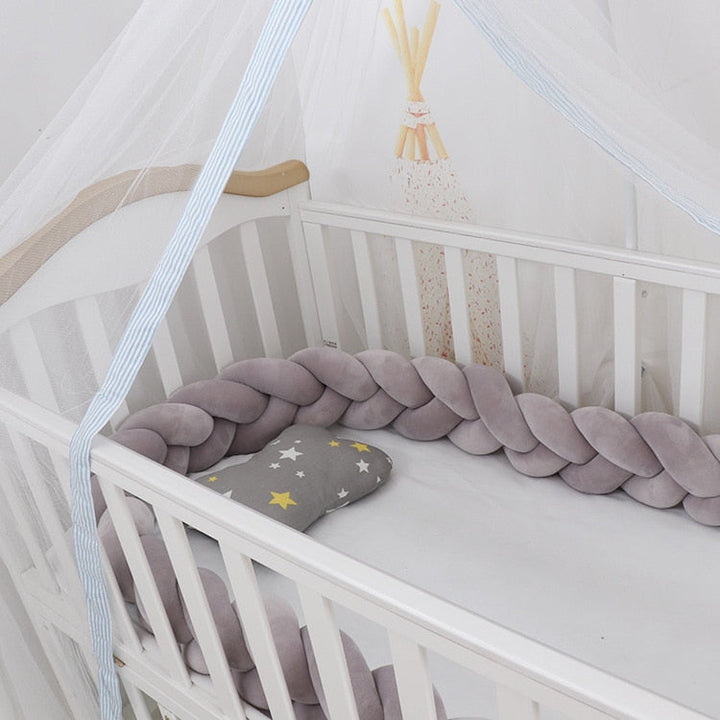 Decoratief gevlochten babykussen in neutrale kleur, perfect voor een moderne kinderkamer decoratie.
