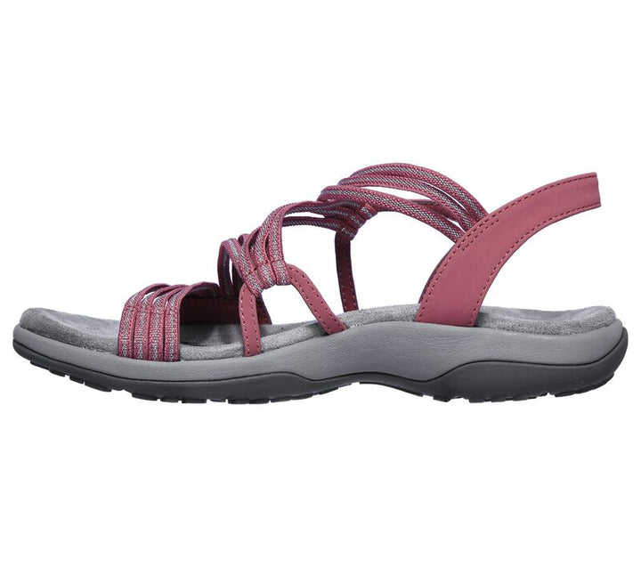 Een vrouw draagt casual roze dames sandalen op het strand, genietend van het comfort en de lichte pasvorm.