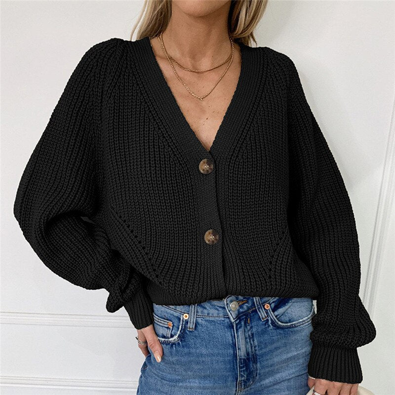 Effen damesvest of pullover met lange mouwen en losse pasvorm. Trendy geknoopte details voor damesmode.