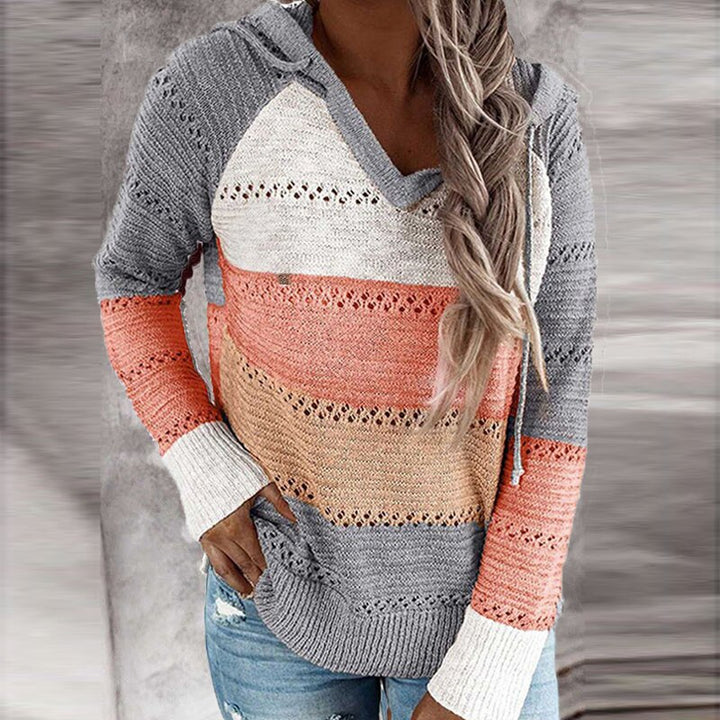 Close-up van de unieke patchwork details op deze comfortabele dames sweater met capuchon. Trendy dameskleding.