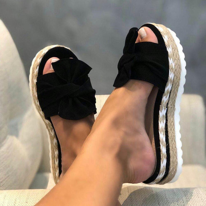 Modieuze dames plateau sandalen van bovenaf, met opvallend knoopdetail en brede band.