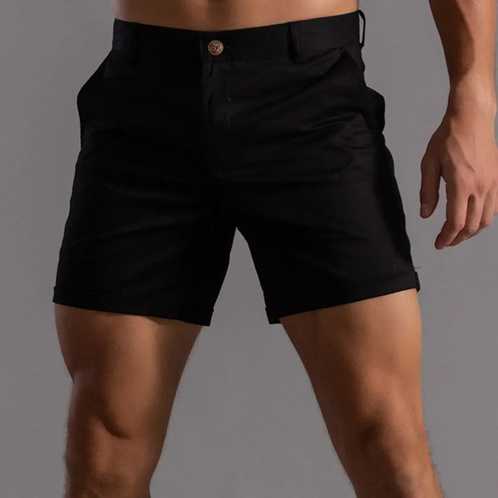 Man draagt grijze chino shorts met een casual overhemd, perfect voor zomercomfort.