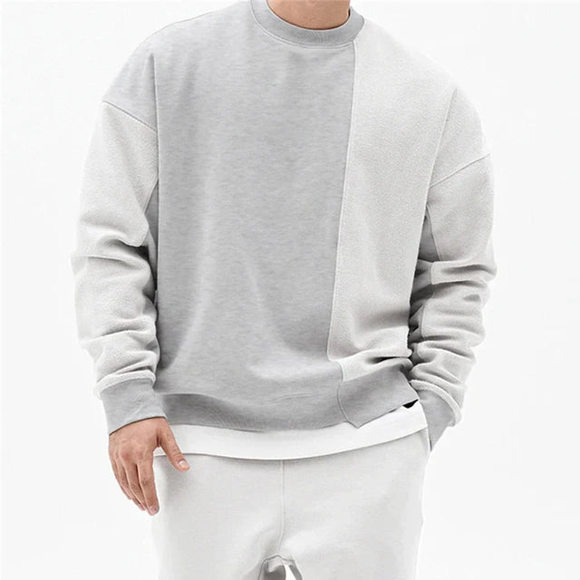 Oversized heren sweater met ronde hals en moderne asymmetrische naad, voor een comfortabele en warme winterlook. Herenmode.