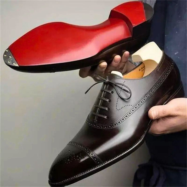 Zwarte heren pakschoenen met elegante brogue details en vetersluiting, ideaal voor formele gelegenheden of zakelijk gebruik.