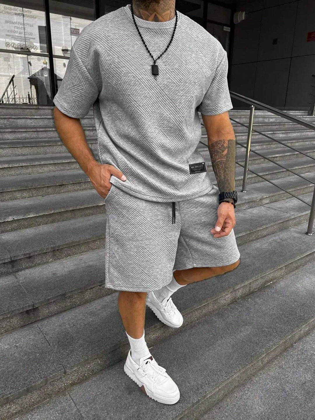 Moderne heren casual zomerset: sportieve korte mouwen en shorts voor een stijlvolle zomerlook.