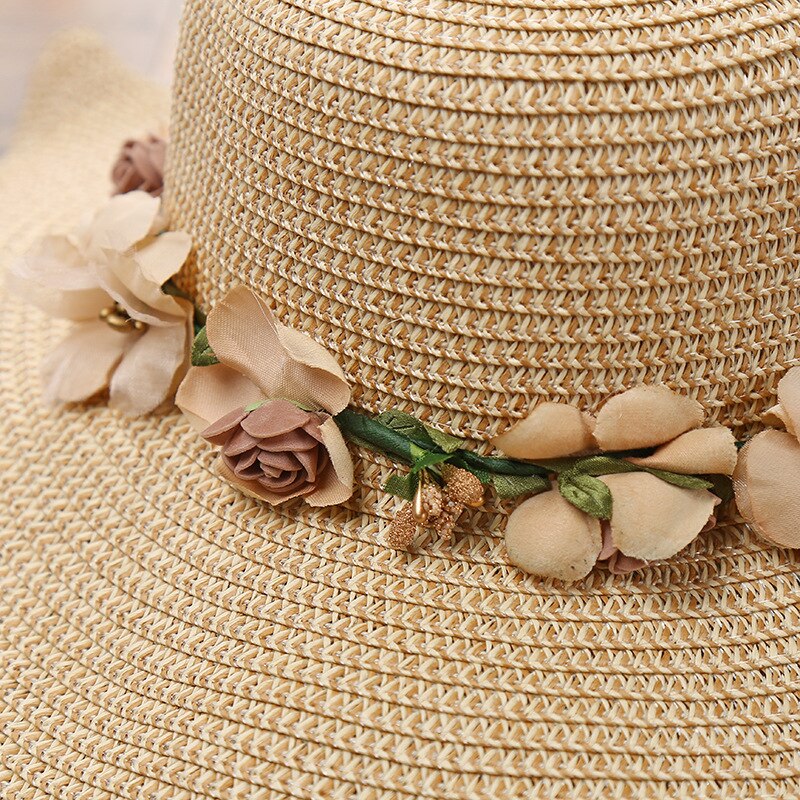 Modieuze dames strandhoed, khakikleurig met delicate bloemen. Elegant accessoire voor zonnige dagen en outfits.