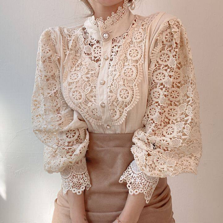 Model draagt klassieke damesblouse met pofmouwen en kanten afwerking, ideaal voor kantoor of vrije tijd.