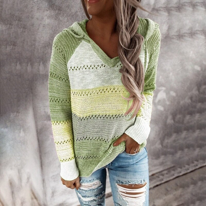 Model draagt comfortabele dames patchwork sweater met capuchon en lange mouwen. Ruime pasvorm voor casual mode.