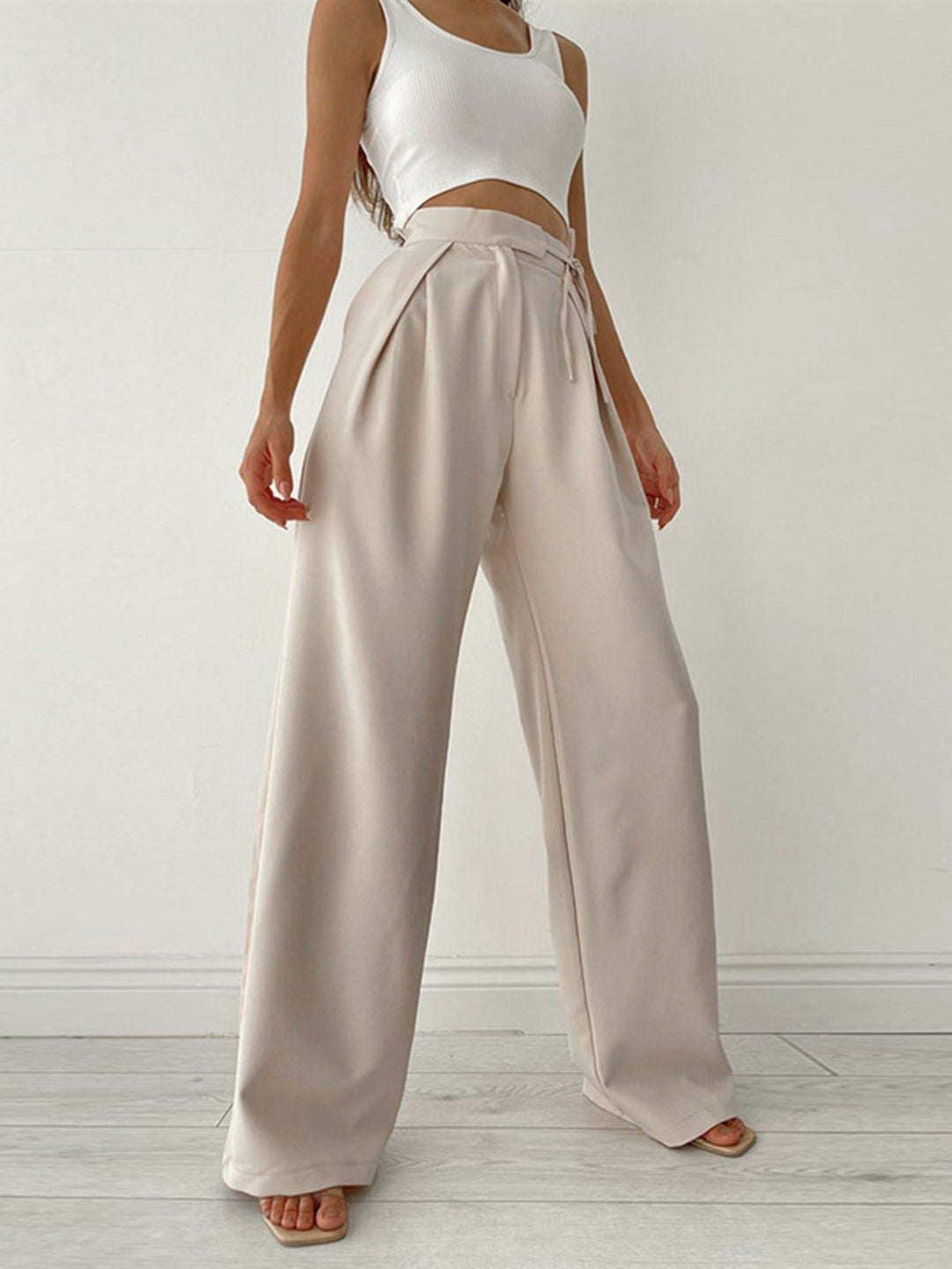 Comfortabele beige high waist pantalon met wijde pijpen en taille strik, voor een moeiteloos elegante stijl.