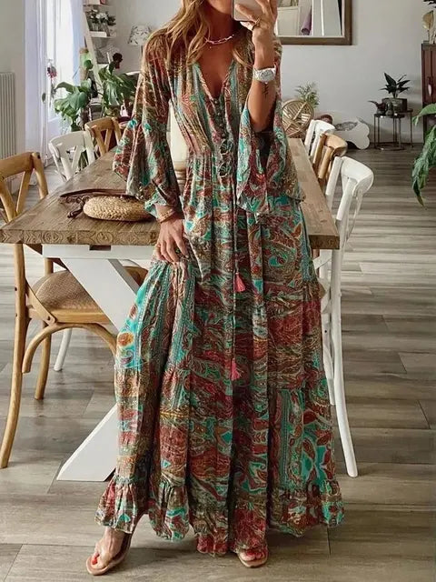 Vrouwelijke model draagt lange bohemian maxi jurk met kleurrijke bloemenprint en wijdvallende mouwen, casual look.