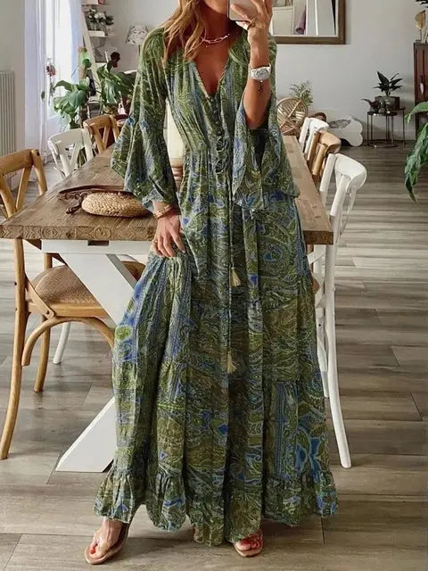 Close-up van de bloemenprint op een dames bohemian maxi jurk met zwierige wijde mouwen, hoge taille model.