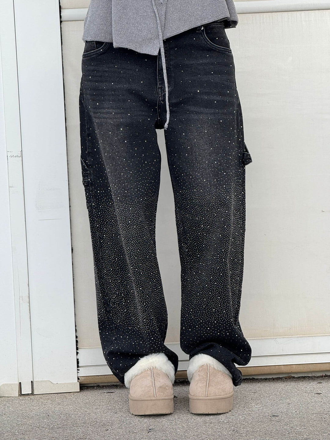 Close-up van de schitterende rhinestones op deze trendy wide leg dames jeans.