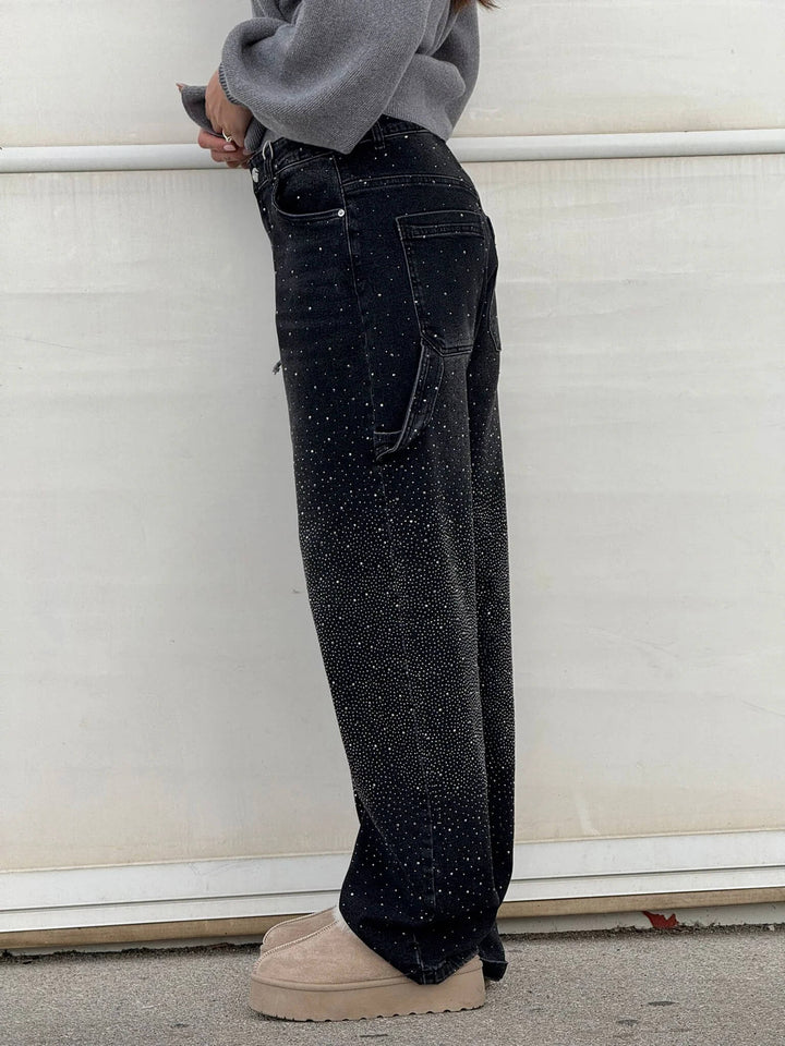 Dame draagt comfortabele wide leg jeans met strassteentjes; losse pasvorm en trendy snit.