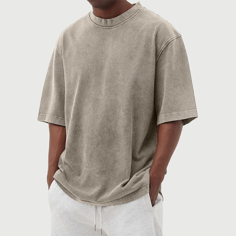Man draagt comfortabel heren t-shirt met gewassen look en relaxte pasvorm, ideaal voor ontspanning.