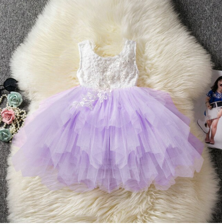 Detail van kanten lijfje en delicate versieringen op elegante meisjes prinsessenjurk. Mooie kinderkleding.