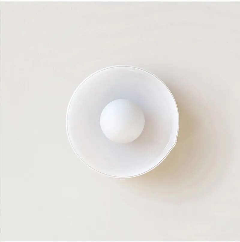Scandinavische glazen plafondlamp gemonteerd in een moderne keuken, heldere en functionele verlichting.