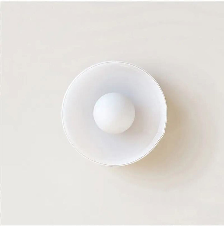 Scandinavische glazen plafondlamp gemonteerd in een moderne keuken, heldere en functionele verlichting.