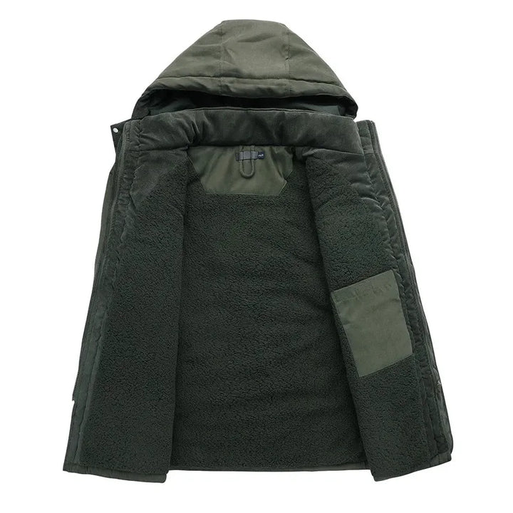 Model draagt robuuste heren militaire parka. Warme winterjas met capuchon, ideaal voor koude dagen en outdoor avonturen.