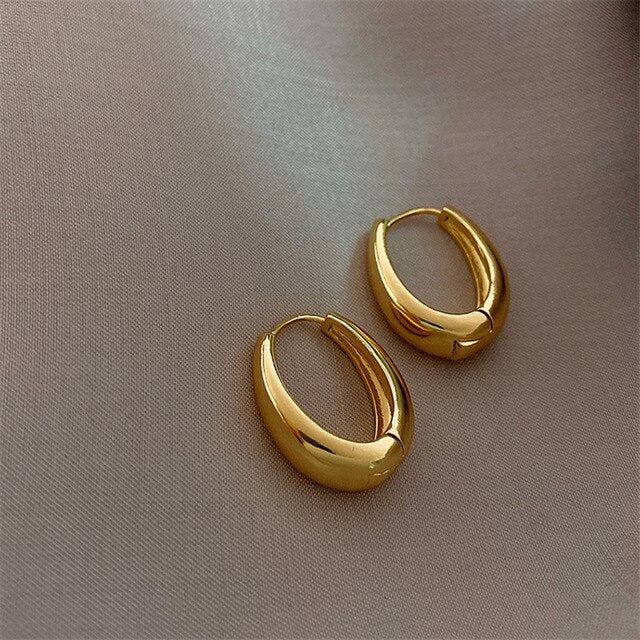 Klassieke gouden oorringen voor dames. Tijdloze elegante sieraden van verguld roestvrijstaal.