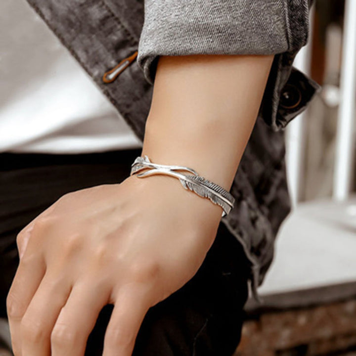 Elegante unisex armband met glanzende verzilverde veren. Verstelbaar ontwerp, perfect als beschermend cadeau.