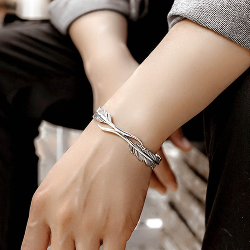 Close-up van een verstelbare unisex armband met fijne verzilverde veren. Een stijlvol sieraad voor elke pols.