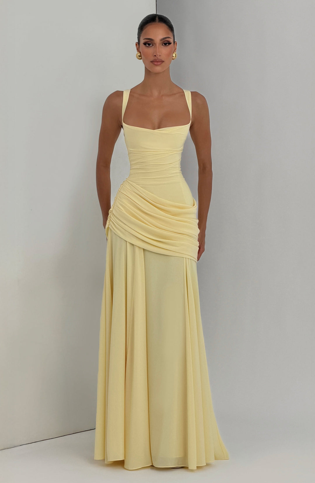 Zomerse gele maxi jurk met elegante twist cowl halslijn. Een modieuze en vrouwelijke gedrapeerde jurk.