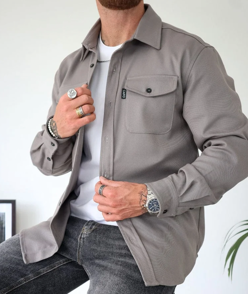 Man draagt casual longsleeve overhemd met borstzakken, ideaal voor een relaxte maar modieuze look.