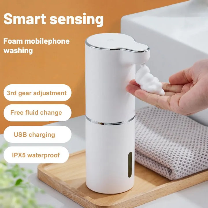 Witte automatische schuimzeepdispenser voor contactloos handen wassen in badkamer of keuken.