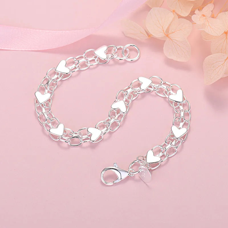 Elegante verzilverde dames schakelarmband met hartjes; een klassiek sieraad en stijlvol accessoire.