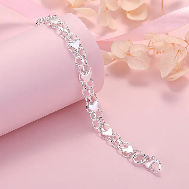 Verzilverde schakelarmband voor dames met fijne hartjes, een elegant en klassiek mode-sieraad.
