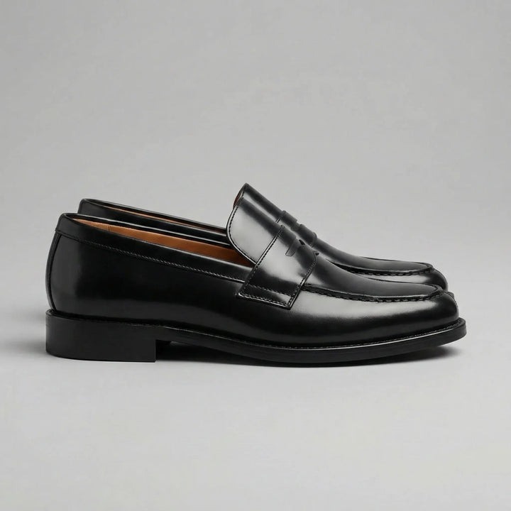 Elegante slip-on heren pennyloafers in zwart leer met ronde neus, ideaal voor een tijdloze look.